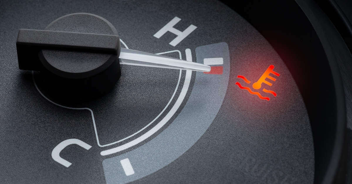 A vehicle's temperature gauge needle, pointing to the high-temperature zone, with the red warning light illuminated.